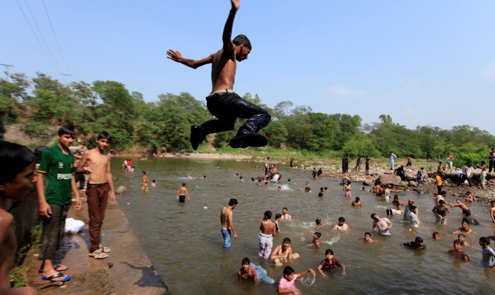 Un hombre salta al agua para refrescarse del calor en un día caluroso de verano en Islamabad , Pakistán.-REUTERS / Faisal Mahmood