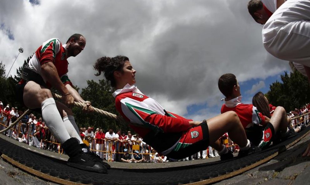 Dos miembros del equipo Berriozar Kirol Elkartea de Sokatira (tiro de cuerda), durante el torneo de San fermín de Sokatira 4x4 mixto, dentro de los campeonatos de deporte rural que tienen lugar en la pamplonesa plaza de Los fueros. EFE/Javier Lizón