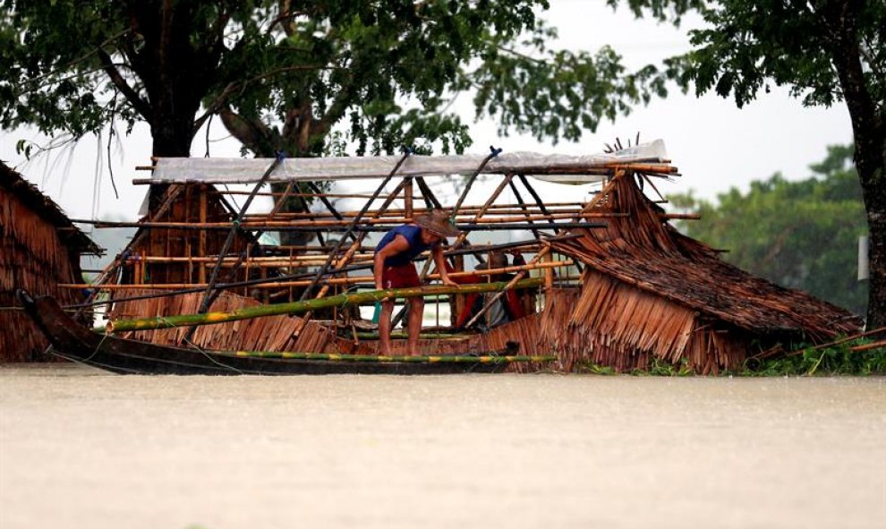 Un hombre trabaja en la reconstrucción de su alojamiento temporal afectado por la subida del nivel del agua cerca de la autopista inundada de Rangún-Pathein, próxima a la localidad de Darka, en la región de Ayeyarwady (Birmania). EFE/Lynn Bo Bo