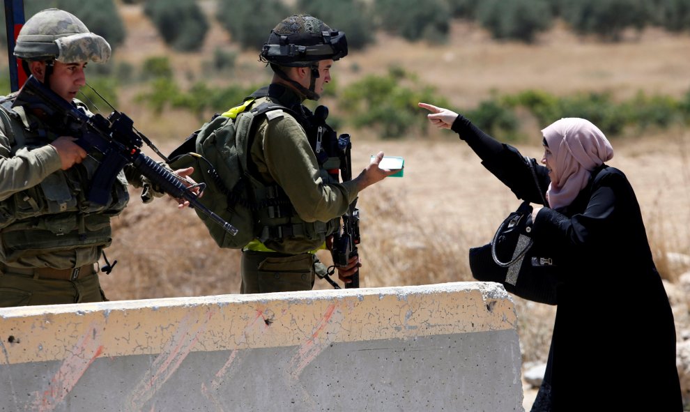 Una mujer palestina discute con soldados del ejército israelí en el campo de refugiados de Cisjordania Al- Fawwar, al sur de Hebrón. REUTERS/Mussa Qawasma