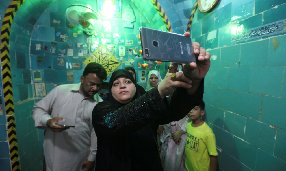 Una mujer toma un selfie en el interior del santuario del Imam Mahdi en el cementerio de Wadi al-Salam (el 'Valle de la Paz'), en Nayaf, al sur de Bagdad. REUTERS / Alaa Al-Marjani