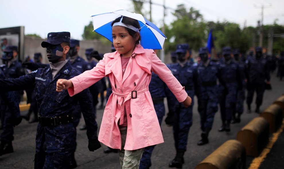 Una chica marcha junto a los soldados salvadoreños durante el desfile conmemorativo Día de la Independencia, en San Salvador, El Salvador. REUTERS/Jose Cabezas