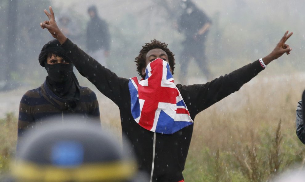 Inmigrantes y policías antidisturbios franceses durante una protesta cerca de la zona conocida como la "jungla" donde viven en Calais, Francia. REUTERS / Pascal Rossignol