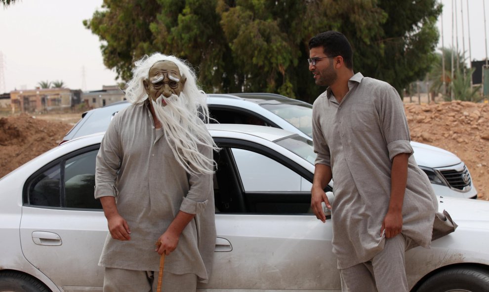 Un hombre con una máscara llega para divertir a los heridos en un hospital de campaña en Sirte, Libia. REUTERS / Hani Amara