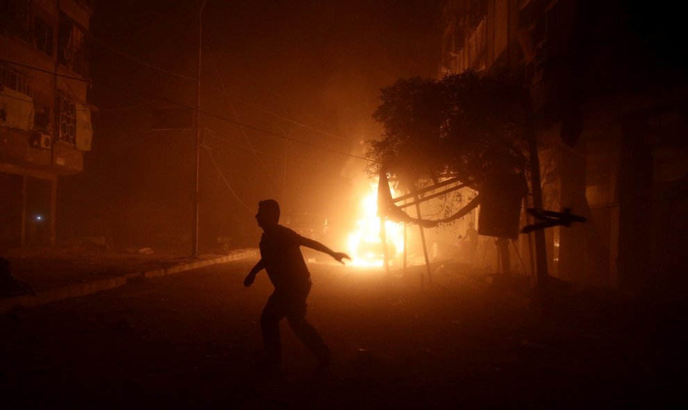 Un hombre corre lejos de un coche en llamas después de un ataque aéreo en el barrio rebelde de Douma, en Damasco, Siria. REUTERS / Bassam Khabieh