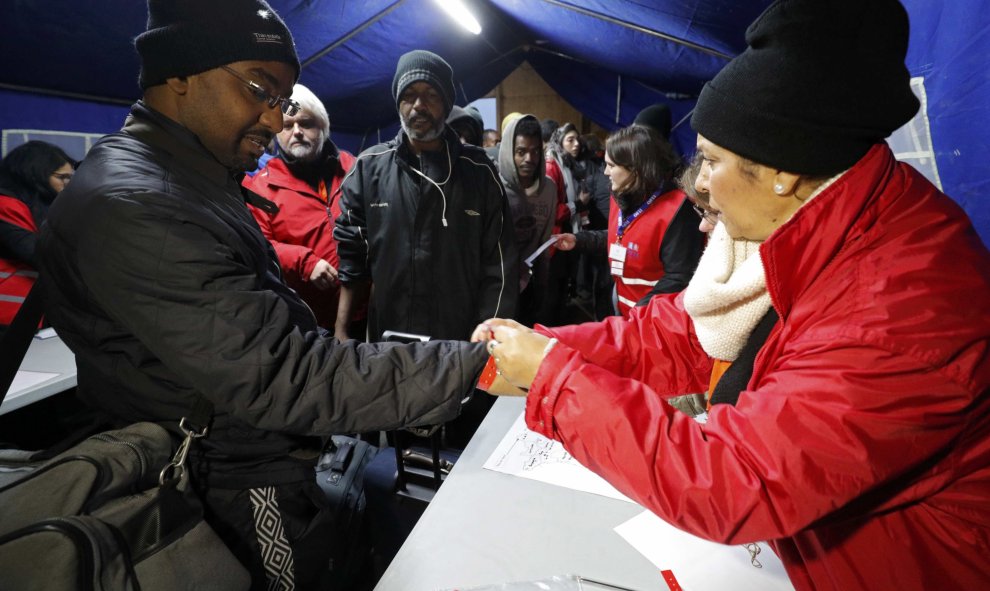 Un inmigrante en la 'Jungla' de Calais recibe una pulsera de color antes de ser trasladado a un centro provisional en Francia. REUTERS/Philippe Wojazer