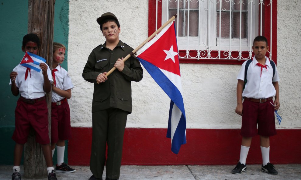 Un grupo de niños espera en la calle la llegada de la caravana que porta las cenizas de Fidel Castro en Bayamo, Cuba. REUTERS