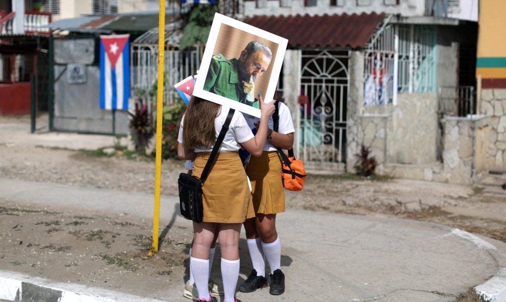 Unas escolares sujetan una fotografía de Fidel Castro en Buenaventura, Cuba, por donde ha pasado la caravana con las cenizas del exmandatario cubano. REUTERS