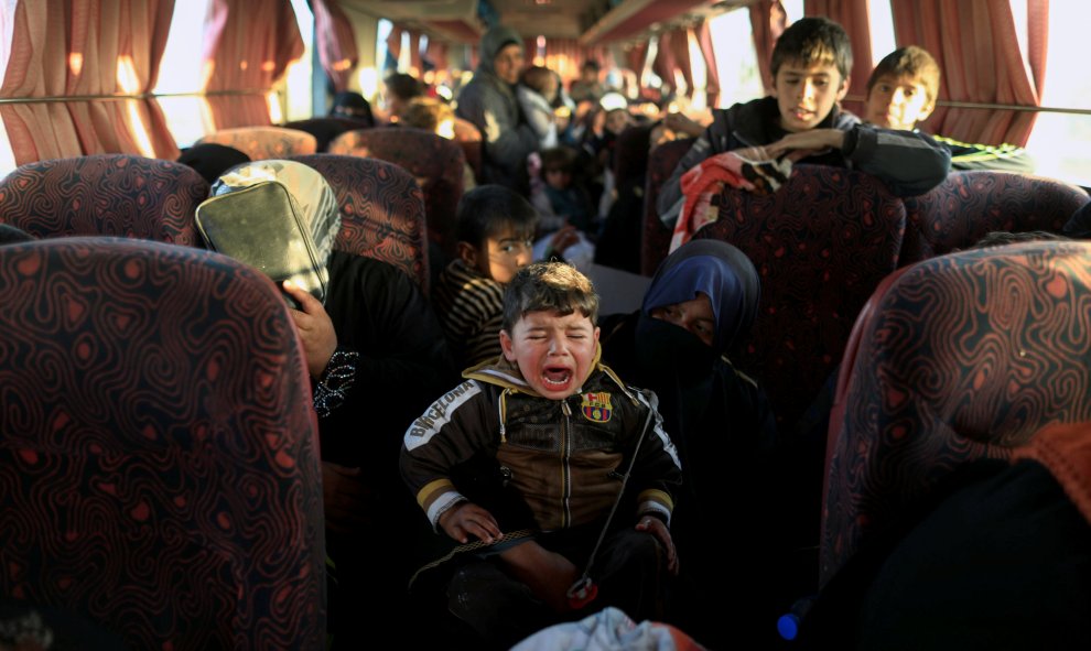 Un niño, que huye de una aldea controlada por los combatientes del Estado Islámico, llora dentro de un autobús antes de dirigirse al campamento de Hammam Ali, al sur de Mosul, Irak. REUTERS/Zohra Bensemra