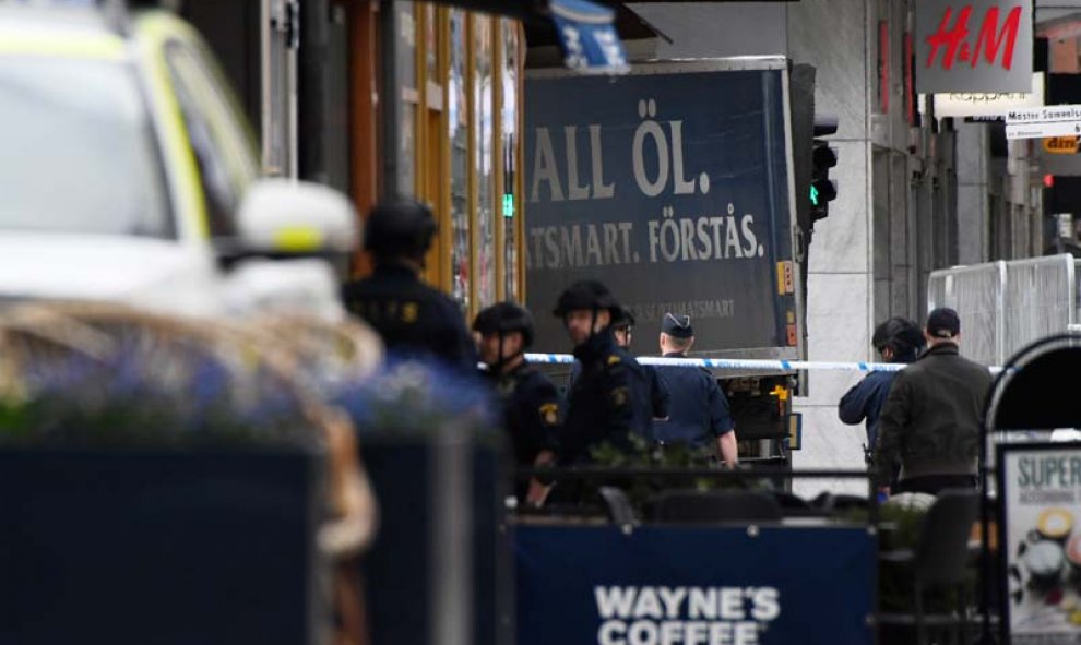 En esta imagen se puede ver el camión empotrado contra un edificio rodeado de policías. | AFP