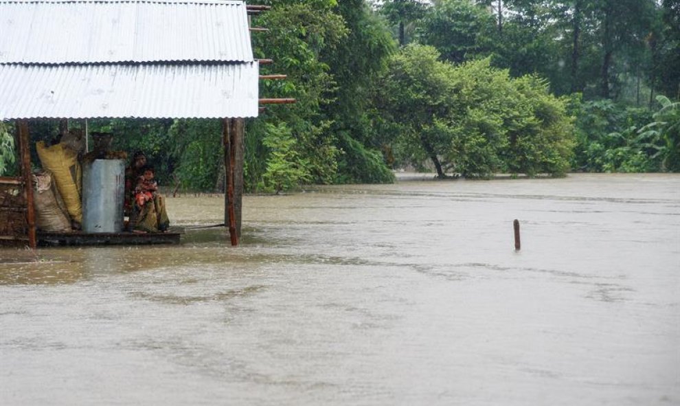 Una mujer y un niño, en medio de las inundaciones en la aldea de Topa en el districto de Saptari, Nepal. EFE/EPA/NARENDRA SHRESTHA