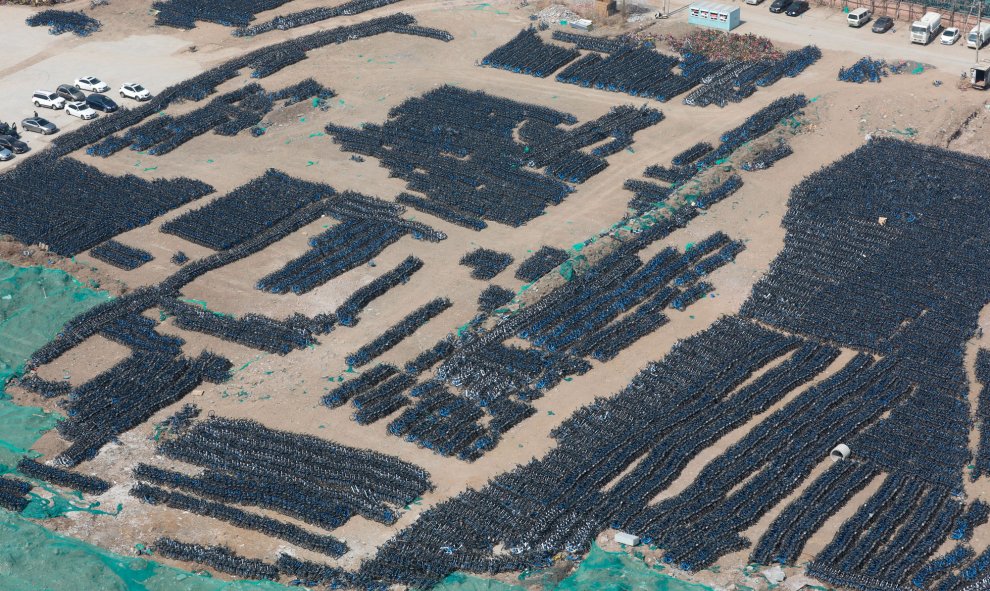 Miles de bicicletas de alquiler esperan a ser reparadas en un aparcamiento al aire libre en Pekín (China). Un total de 70.000 bicicletas de la empresa Bluegogo fueron trasladadas a este aparcamiento para ser reparadas tras el cierre de la compañía en novi