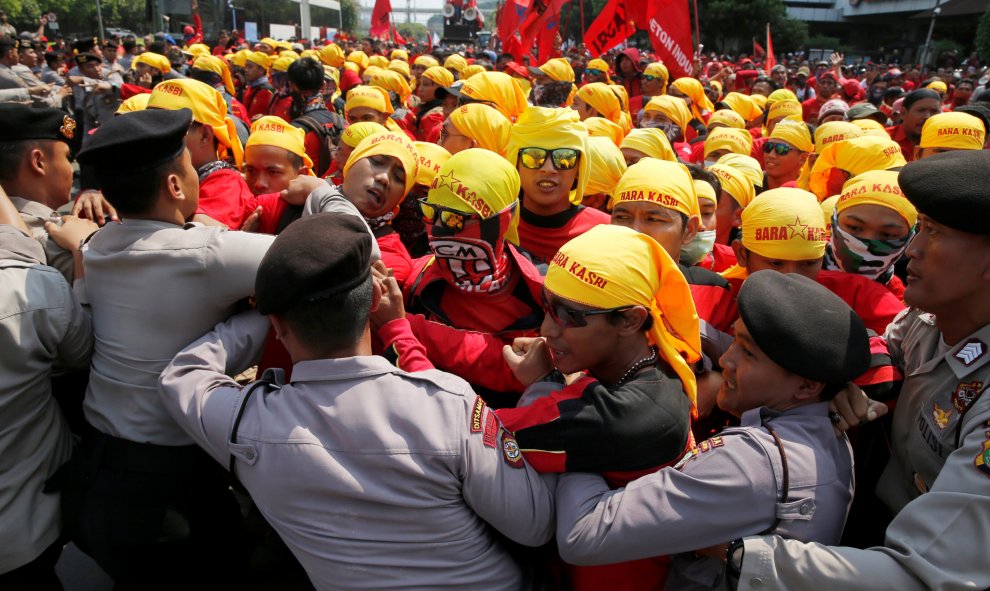 Trabajadores inonesios se enfrentan a los policías para poder acceder al distrito financiero de Yakarta, en la manifestación del Primero de Mayo.. REUTERS/Beawiharta