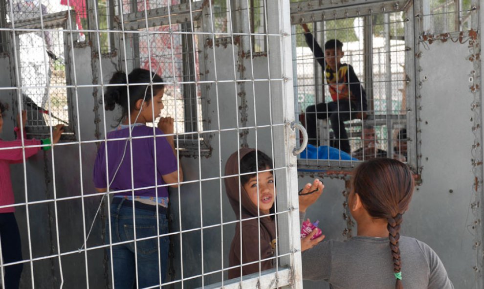 Niños en la fila de reparto de comidas, enrejada, como otro punto caliente conflictivo entre los internos por la escasez de alimentos. / M.I