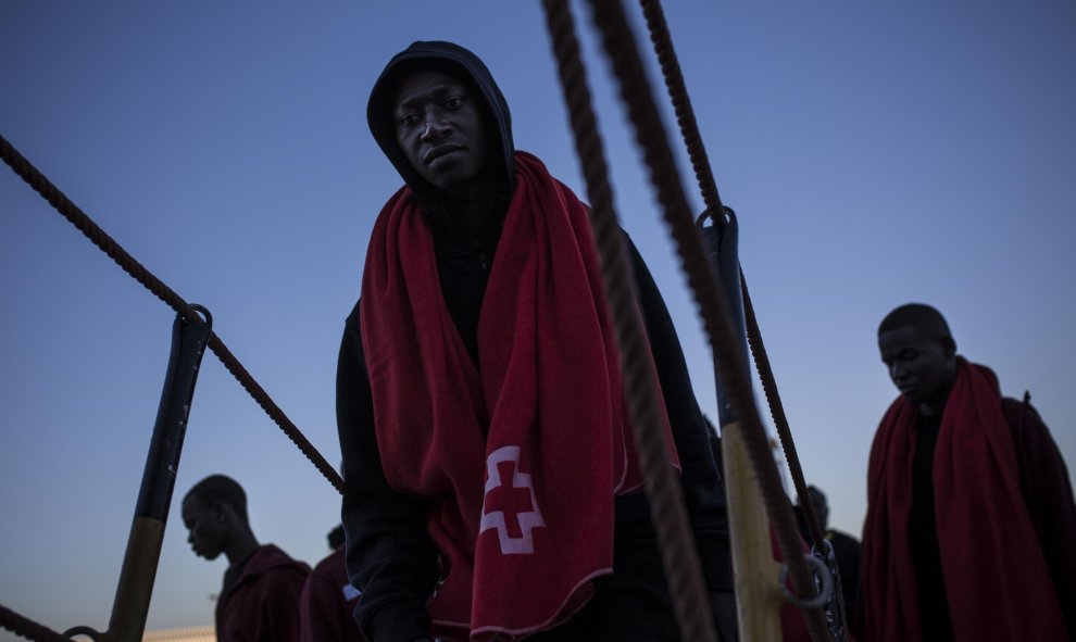 Un joven migrante sube a borde de un barco de Sasemar junto a otros 200 personas para pasar la noche tras ser rescatado de una patera durante el fin de semana. JAIRO VARGAS