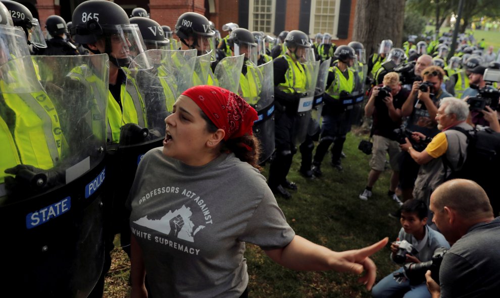 Una manifestante se encara con los policías desplazados para impedir que entraran en el parque Robert. E. Lee | REUTERS