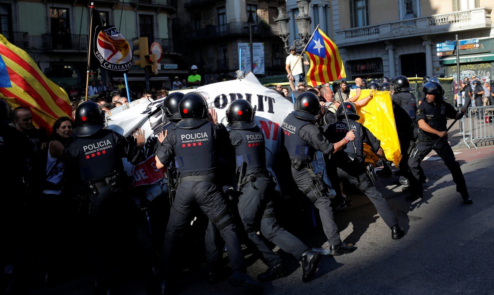 Comienzan los primeros forcejeos entre independentistas y los Mossos. | Jon Nazca / Reuters