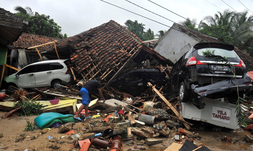 Un hombre trata de rescatar algunos objetos de las ruinas de su casa, arrasada por los efectos del tsunami en Indonesia./REUTERS