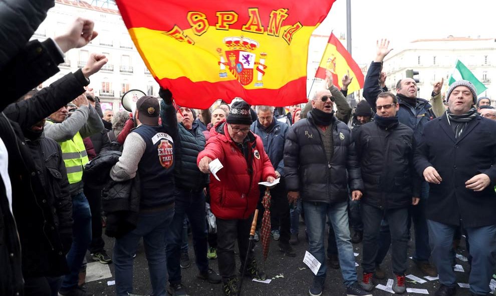 Los taxistas queman un cartel del PP con la cara del presidente de la Comunidad de Madrid en  segundo día consecutivo en la madrileña Puerta del Sol. (KIKO HUESCA | EFE)