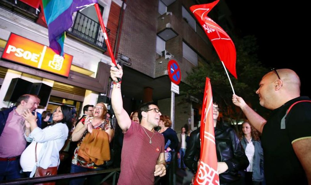 Personas congregadas a las puertas de la sede del PSOE en Madrid desde donde siguen el escrutinio de las elecciones. EFE/ Javier López