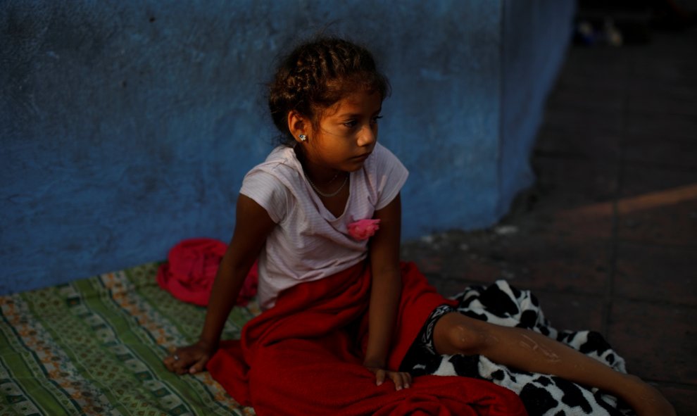 Una niña nicaragüense se despierta después de dormir en el suelo mientras espera en la fila para ingresar a la COMAR. / Reuters