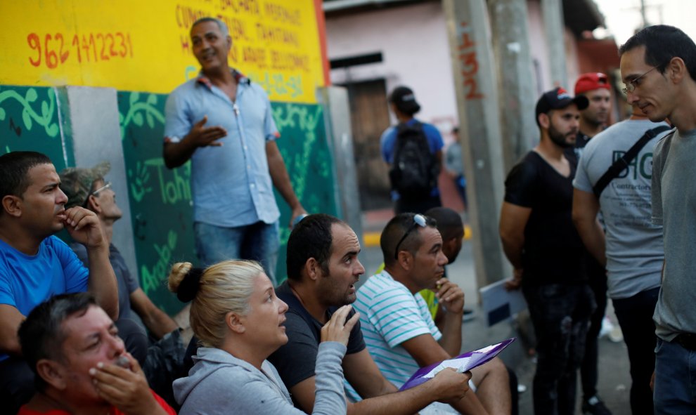 Los migrantes cubanos conversan mientras esperan en la fila para ingresar a la Comisión Mexicana de Asistencia a Refugiados (COMAR). / Reuters