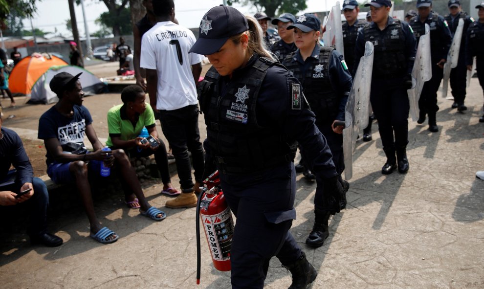 Miembros de la Policía Federal Mexicana caminan hacia las instalaciones de migración de Siglo XXI en Tapachula, México. / Reuters