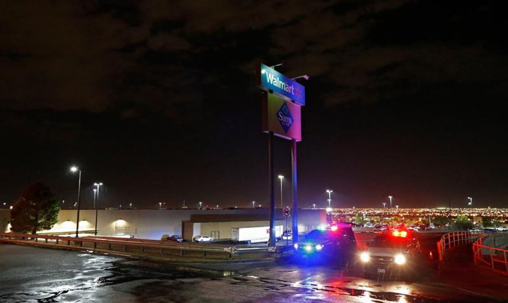 Los coches de la policía estacionados debajo del letrero de Walmart bloquean una calle afuera mientras investigan los tiroteos masivos en un Walmart en El Paso, Texas. EFE/EPA/LARRY W. SMITH