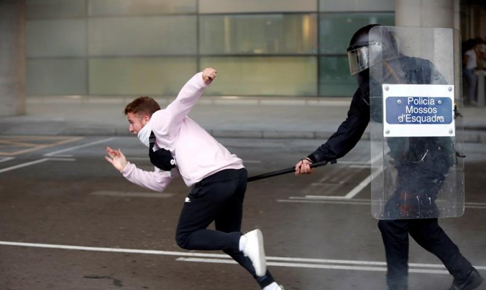 14/10/2019.- Miembros de los Mossos d'Esquadra cargan contra los centenares de personas que se agolpan ante el Aeropuerto del Prat. EFE/Toni Albir