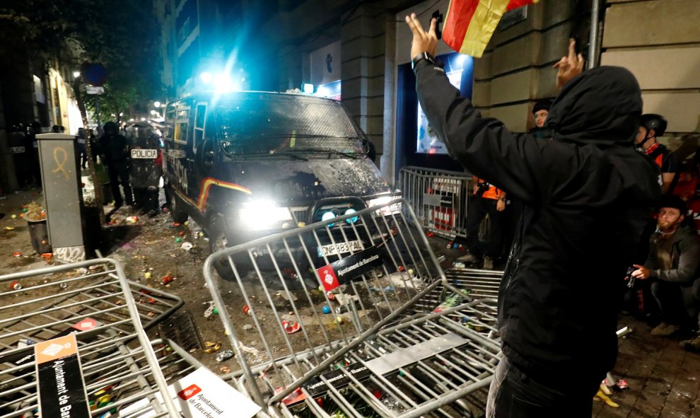 Un manifestante increpa a agente de Policía frente a las vallas derribadas frente a la Jefatura Superior de Policía en Barcelona.- REUTERS/ ALBERT GEA