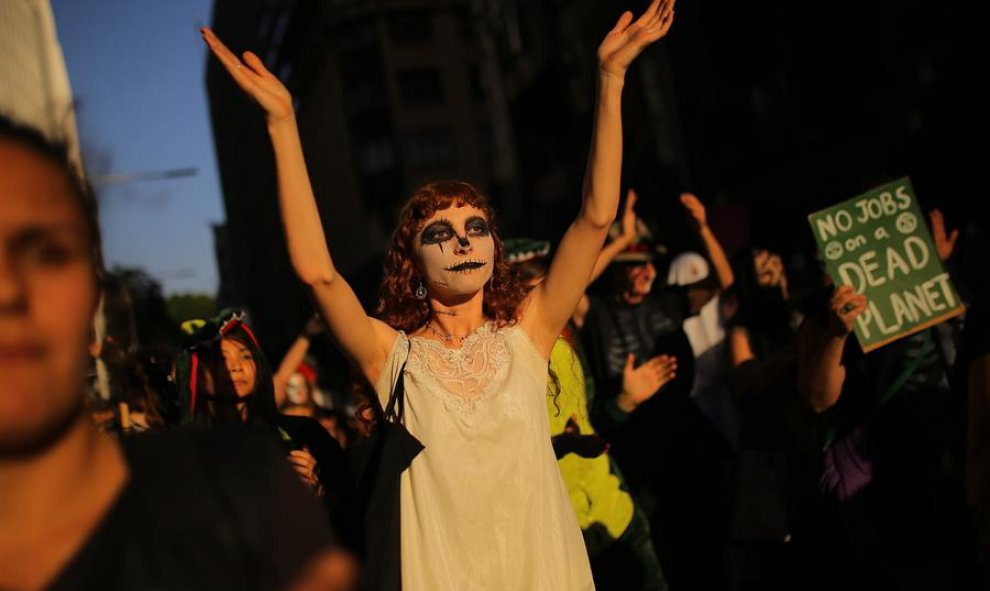 Manifestantes disfrazados participan en una protesta de Extinction Rebellion. EFE