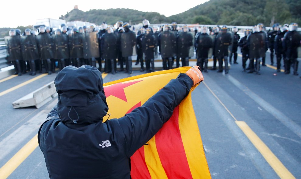 12.11.2019 / Un hombre frente a policías franceses en la autopista AP-7 en el lado francés de la frontera franco-española. REUTERS / Rafael Marchante