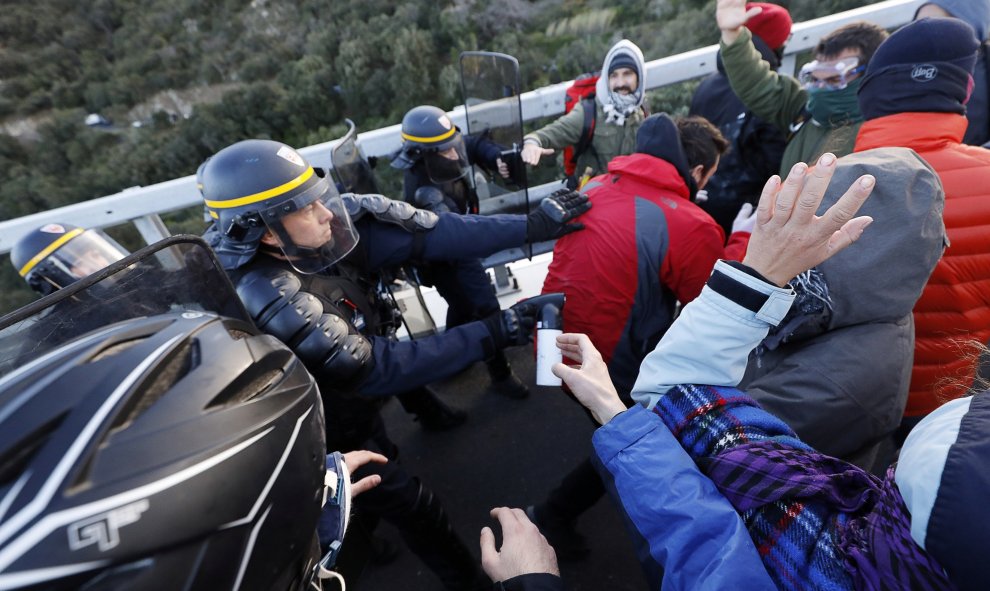 Miembros del grupo de protesta catalán Tsunami demócrata se enfrentan con agentes de policía franceses en la autopista AP-7 en el lado francés de la frontera franco-española. REUTERS / Rafael Marchante