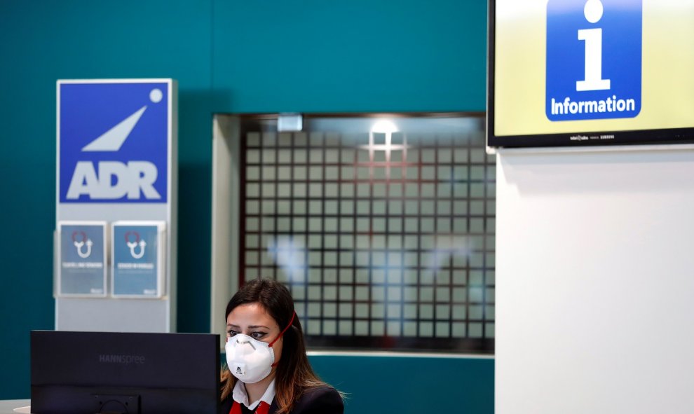 Una trabajadora del aeropuerto de Fiumicino en Roma se protege con una máscara después de que se confirmara el primer caso de coronavirus en Italia. REUTERS/Yara Nardi