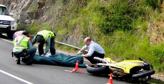 Miembros de la Guardia Civil de Tráfico y del servicio de emergencias se disponen al traslado de una de las tres víctimas mortales, tres motoristas, que fallecieron hoy en el accidente de tráfico registrado en el kilómetro 16 de la carretera AS-15, en el 