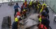 Fotografía facilitada por la Armada de Malasia que muestra a miembros del buque de la Armada Malasia "Lekir" recuperando una pieza del Airbus 320-200 de AirAsia siniestrado el domingo en el mar de Java con 162 personas a bordo, frente a la costa de Pangka