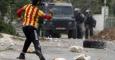 Un niño palestino tira una piedra a policías israelíes durante una protesta. REUTERS/Abed Omar Qusini