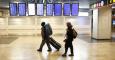 Unos jóvenes buscan su vuelo en los paneles informativos en el aeropuerto dolfo Suárez-Barajas. REUTERS