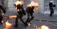 El fuego de unos cócteles molotov alcanza a unos agentes de policía en unos enfrentamientos con manifestantes cerca de la sede del Parlamento en la Plaza Syntagma de Atenas (20 de octubre 2011). REUTERS / Yannis Behrakis