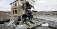 Una familia coloca flores y ora por sus parientes víctimas del terremoto y el tsunami del 11 de marzo de 2011 en el país. EFE/KIMIMASA MAYAMA