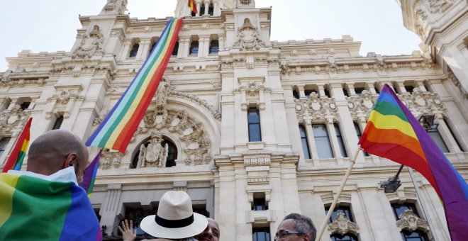 Una bandera con los colores del arco iris, símbolo LGTB, ondea en el Ayuntamiento de Madrid mientras algunas parejas homosexuales lo celebran en los aledaños del consistorio. REUTERS