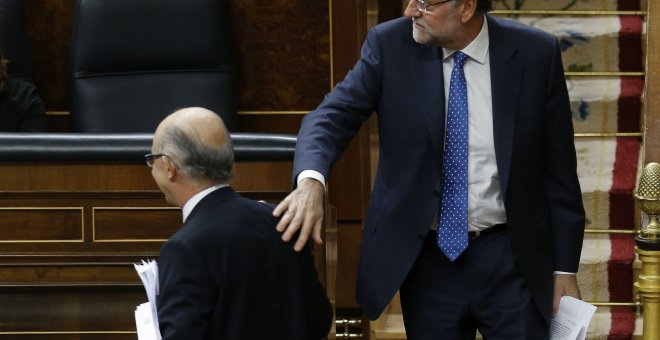 El presidente del Gobierno, Mariano Rajoy, felicita al ministro de Hacienda, Cristóbal Montoro, tras la intervención de éste ante el pleno del Congreso para defender los Presupuestos Generales del Estado para 2016. EFE/Paco Campos