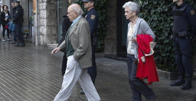 Jordi Pujol y su esposa, Marta Ferrusola, salen de su domicilio durante el registro de la UDEF. EFE/Quique García