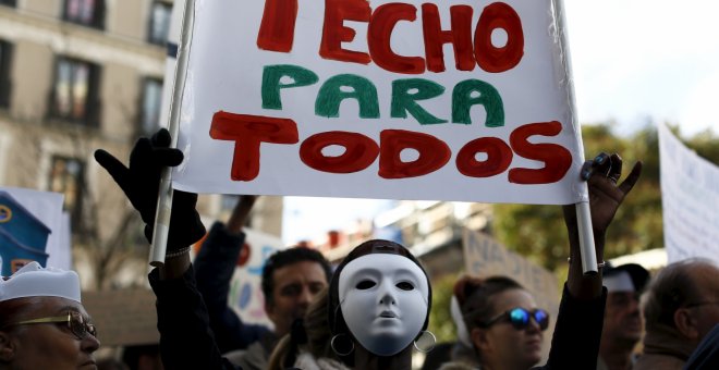 Un manifestante sujeta una pancarta donde se lee "TECHO PARA TODOS" en la protesta convocada por la plataforma "Nadie sin Hogar" por el derecho a la vivienda, en el centro de Madrid, España, 26 de noviembre de economía 2015. REUTERS / Paul Hanna