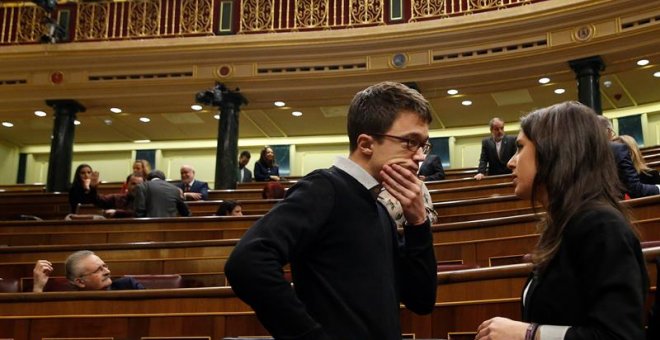 Los diputados de Podemos Iñigo Errejón e Irene Montero conversan en el hemiciclo del Congreso.- EFE