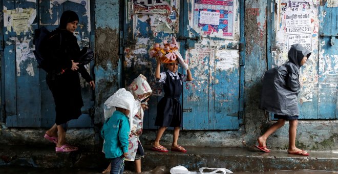 Unos niños se dirigen a la escuela tras las grandes inundaciones que ha sufrido Mumbai, en la India/REUTERS