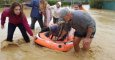 Varias personas evacuan a unos perros de las inundaciones en Málaga.