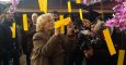 La alcaldesa de Madrid, Manuela Carmena, escribe "Que se acabe la guerra en Siria" en un árbol de los deseos./ J. Y.