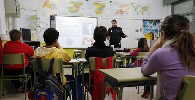 Alumnos atienden a una charla sobre acoso escolar impartida por un agente de Policía.