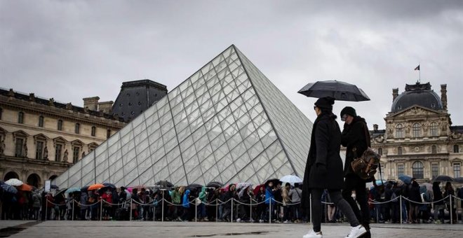 Turistas ante el museo del Louvre, en París. / IAN LANGSDON (EFE)